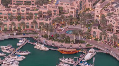 Dubai Marina'nın havadan üstten gündüz geceye geçiş saati. Dubai, Bae gün batımından sonra yüzen yatlar ve tekneler ile gezinti ve kanal. Işıklı binalar ve çeşme