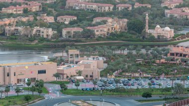 Jumeirah göl kuleleri bölgesinde, Birleşik Arap Emirlikleri yakınlarında Dubai şehrinde cami ve araba parkı olan apartman ve villaların hava manzarası. Gökdelenden üst görünüm
