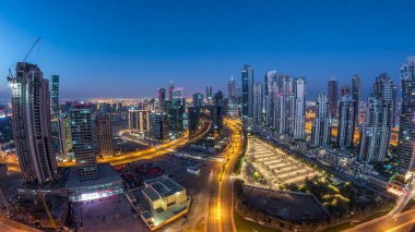 Dubai İş Sahası Panorama 'sı gece gündüz geçiş zamanı. Gökdelenleri ve hareket eden uzun gölgeleri olan gökdelenler. Gün doğarken trafik vardı..