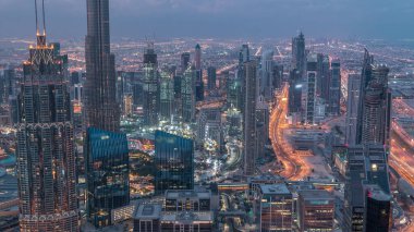 Dubai Şehir Merkezi gökdelenleri ve Burj Halife 'nin gece gündüz geçiş yaptığı fütüristik şehir manzarası. Gündoğumundan önce çatıdan modern kuleleri ve inşaatı olan sabah manzarası