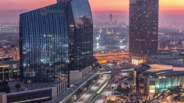 Dubai şehir merkezi caddesi yoğun trafik ve gece ile gökdelenler geçiş zamanı. Modern yol ve alışveriş merkezi manzaralı şehir binaları. Şeyh Muhammed bin Rashid Bulvarı