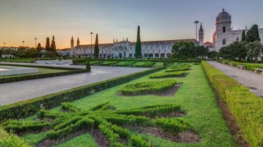 Günbatımında Mosteiro dos Jeronimos (Hieronymites Manastırı), Lizbon 'un Belem ilçesinde, bahçede yeşil çimenlik alan. Manueline stilinin tipik bir örneği. Dünya Mirası Sitesi