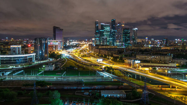 Night panorama of the city traffic timelapse and Building of Moscow International Business Center (Moscow-City). Aerial top view from rooftop near Kievskiy railway station