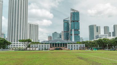 Singapur Rekreasyon Kulübü 'yle Skyline ve arka plandaki gökdelenler. Gökyüzündeki yeşil çimenler ve bulutlar
