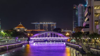 Singapur finans bölgesinin Skyline 'ı ve Elgin Köprüsü' nün arkasındaki Marina körfezi ve Singapur Nehri gece hipervanesi. Parlamento binası sol tarafta.