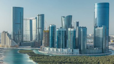 Abu Dabi 'deki Al Reem Adası' ndaki binalar yukarıdan zaman çizelgesi. Bulanık bir sabahta Al Reem Adası 'nın havadan görünüşü gökdelenlerin yansımasını gösteriyor..