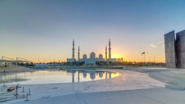 Şeyh Zayed Ulu Cami Abu Dabi 'de gün batımı saatinde, BAE. Wahat Al Karama 'dan akşam manzarası ve su yansımaları