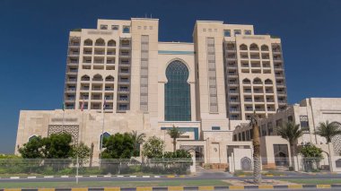 Ajman 'da 5 yıldızlı lüks bir otelin girişinde, UAE' nin Arap Körfezi turkuaz sularının yakınındaki bir yolda trafik vardı..