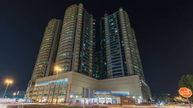 Ajman gece hiperhızında modern yeni kuleler. Ajman 'ın yerleşim yeri ve ofis gökdelenleri olan şehir manzarası. Birleşik Arap Emirlikleri.