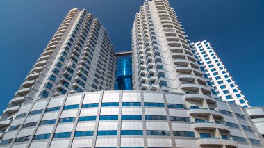 Ajman zaman ayarlı hiperhızlandırılmış gümüş kuleleri olan modern yeni mavi. Ajman 'ın yerleşim yeri ve ofis gökdelenleri olan şehir manzarası. Birleşik Arap Emirlikleri.