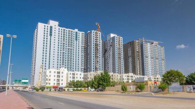 Ajman zaman tünelinde modern yeni kuleler inşa ediliyor. Ajman 'ın yerleşim yeri ve ofis gökdelenleri olan şehir manzarası. Birleşik Arap Emirlikleri.