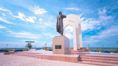 Aktau, Kazakistan 'daki Zhalau Mynbayev Timelapse Hiperlapse anıtı. Hazar Denizi ve Mavi Bulutlu Gökyüzü Sakin Bir Yaz Günü 'nde Saygıdeğer bir zemin oluşturdu