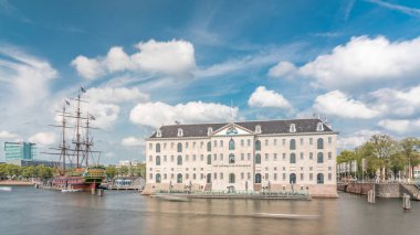 Denizcilik Müzesi 'nin hiperlapse' si ve Amsterdam 'ın deniz kenarı kopyası. Bulutlu mavi gökyüzü. Kültürel aktiviteleri, kanalları ve köprüleri meşhurdur. Amsterdam, Hollanda