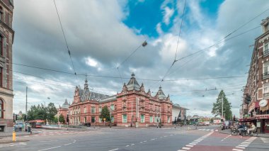 Amsterdam Stedelijk Müzesi modern ve çağdaş sanat eserlerini sergiliyor. Tramvay ve otobüslerle kavşaktan geçen trafik bulutlu bir zaman dilimi altında ilerliyor. Amsterdam, Hollanda