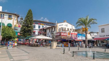 Çok sayıda kafe ve barlar, Attalos II ve Hediyelik eşya heykeli ile Cumhuriyet Meydanı timelapse hyperlapse Antalya'da depolar. Çeşme ön plan üzerinde. Mavi bulutlu gökyüzü yaz gün