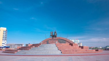 Timelapse Hiperlapse Kazak Kahramanlar Anıtı Makhambet Utemisov ve Isat 'ın Atyrau Şehrinde. Güneşli bir günde Kazakistan 'da Mavi Bulutlu Gökyüzüne karşı haraç açılır