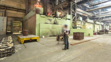 The liquid metal is poured into molds at the metallurgical plant timelapse hyperlapse. Factory workshop with steelmaking furnace. Worker controlling crane of metal melting in furnaces.