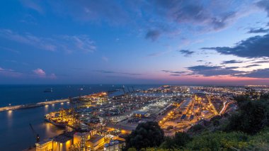 Barcelona Limanı 'ndaki Liman ve Yükleme İskeleleri' nin Gece Dönüşüm Süreci. Montjuic Hill 'den Aerial Top View, Günbatımından sonra şehrin ışıklarıyla sahneyi aydınlatıyor.