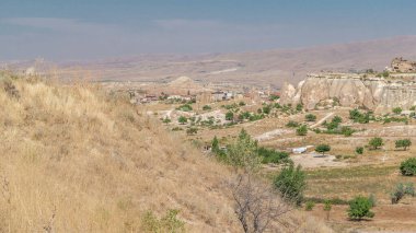 Türkiye 'nin Kapadokya kentindeki Nevsehir' in Kızıl Vadisi ve Gül Vadisi. Aşk vadisi ve peri bacaları Yeşil ağaçlı panoramik manzara