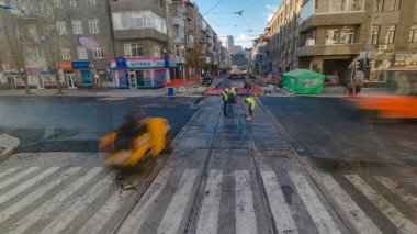 Traktör, yol onarım alanında zaman ayarlı. Yol yapım ekipmanları. İnşaat işçileri yolda asfaltlanıyor..