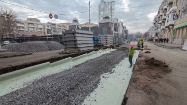 Zaman ayarlı bir yol yapımı buldozer işi. Alt tabakada ezilmiş taş. Destek faaliyetleri ve inşaat halindeki yol. Tramvay raylarının yeniden inşası