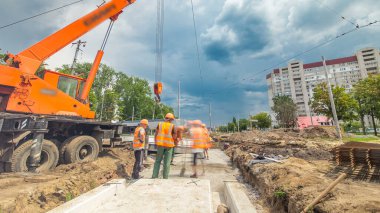 Vinç yol inşaat site timelapse hyperlapse, beton plaka yükleme. Kavganın ve üniforma ile sanayi işçileri. Sokak şehir tramvay yeniden inşası izler