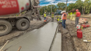 Beton işleri ve yol inşaatı için bir sürü işçi ve mikser hızlandırıcı ile aynı seviyeye gelmek. Metal takviyesine harç dökülüyor. Tramvay raylarının yeniden inşası