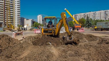 Endüstriyel kazı alanı kazıyor ve inşaat alanındaki eski yol zamanının parçalarını temizliyor. Büyük bir şehirde tramvay raylarının yeniden inşasına hazırlık