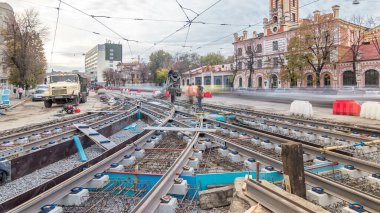 Hazır beton beton mikser timelapse tarafından yol yapmak için çelik takviye koyduktan sonra dökme. İşçi koruyucu maske takviye kaynak ile. Tramvay parça yeniden inşası