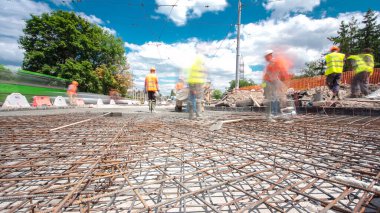Tramvay rayları onarılan ve bakım süreleri yüksek olan yol inşaatı. Metal bir şebekeye beton dökülüyor. Kavşağın ortası..