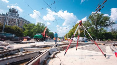Tramvay rayları onarılan ve hiperhızlandırılmış yol inşaatı. Kavşağın ortasındaki tripodun elektronik seviyesi. Yeni toplu taşıma için demiryolu raylarının değiştirilmesi