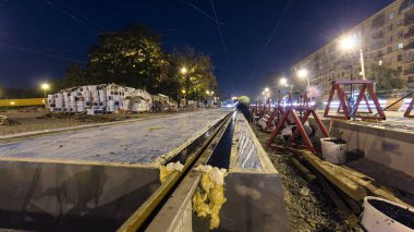 Tramvay rayları montajlarının son aşamasında ve yol gecesinde beton plakalara entegrasyon. Titreşim ve gürültüyü azaltmak için sıvı reçineyle doldurulmuş. Yeniden yapılanma süreci