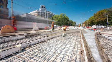 Beton yol yapım birçok işçi ve mikser timelapse hyperlapse ile çalışıyor. Harç metal takviye için dökme. Kaplama ve koruyucu filtre püskürtücü tarafından. Tramvay parça yeniden inşası