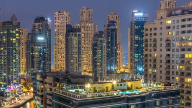 Dubai Yat Limanı hava görünümünü gece geçiş timelapse için bir noktadan günden güneş battıktan sonra. Modern gökdelenler ve konut kuleleri de akşam aydınlatılmış. Yolda trafik