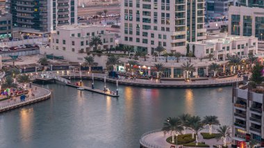 Geçen tekneler ve avuç içi gün gece ile promenade ile lüks Dubai Yat Limanı kanal timelapse geçiş, yukarıdan bakışta akşam güneş battıktan sonra Top. Dubai, Birleşik Arap Emirlikleri