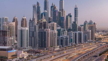 Dubai Yat Limanı gökdelenler hava üstten görünüm güneş doğmadan önce Jlt gelen Dubai gece gün timelapse, Birleşik Arap Emirlikleri için. Işıklı modern kuleleri ve Şeyh zayed yolu üzerinde trafik.