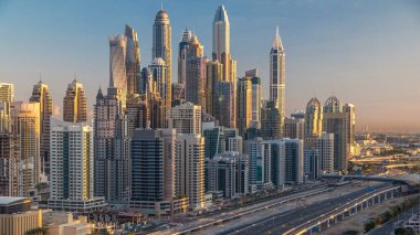 Dubai Yat Limanı gökdelenler hava üstten görünüm Jlt üzerinden sabah Dubai timelapse, BAE güneş doğarken sırasında. Modern kule uzun gölgeler aşağıya taşınması ve Şeyh zayed yolu üzerinde trafik ile.