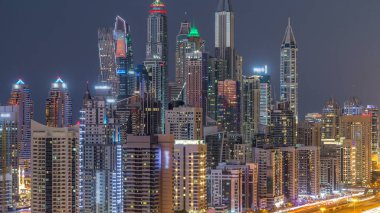Dubai Yat Limanı kuleleri panorama gün gece geçiş timelapse için dönüş ışıkları. Gökdelenler, BAE gece aydınlatma. Hava Jlt görünümünden