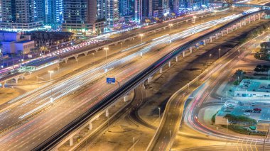 Dubai Yat Limanı ve Jumeirah Lakes Towers ilçe gece timelapse Şeyh Zayed Caddesi üzerinde trafik. Jlt üzerinden hava üstten görünüm
