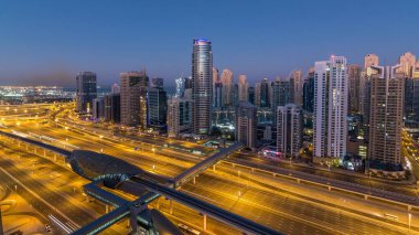 Dubai Yat Limanı gökdelenler hava üstten görünüm güneş doğmadan önce Jlt gelen Dubai gece gün timelapse, Birleşik Arap Emirlikleri için. Işıklı modern kuleleri ve Şeyh zayed yolu üzerinde trafik.