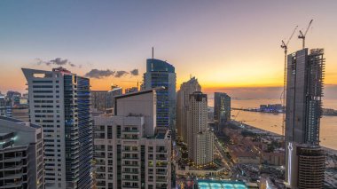 JBR ve Dubai marina gece geçiş timelapse günbatımı hava gün sonra. Modern kuleleri ve gökdelenler, yat ve tekne Körfezi üzerinde yüzen