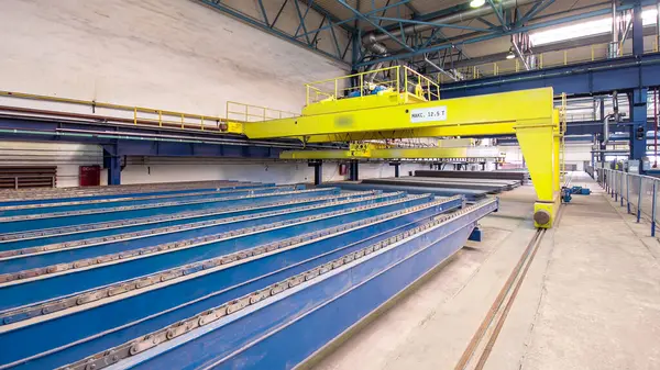 Factory workshop with yellow lifting crane device timelapse hyperlapse, lift loads using lifting magnet, mechanical workshop, metal structures plant. Automated machine for precise metal cutting.