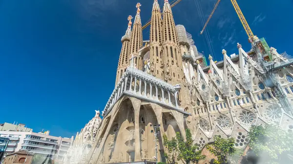Sagrada Familia: İspanya 'nın Barcelona kentindeki Iconic Roma Katolik Kilisesi' nden Timelapse Hyperlapse. Sonbaharın Zarif Yeşilliği ve Mavi Bulutlu Gökyüzünün Altında Açılan Mimari Mucizeye Şahit Ol.