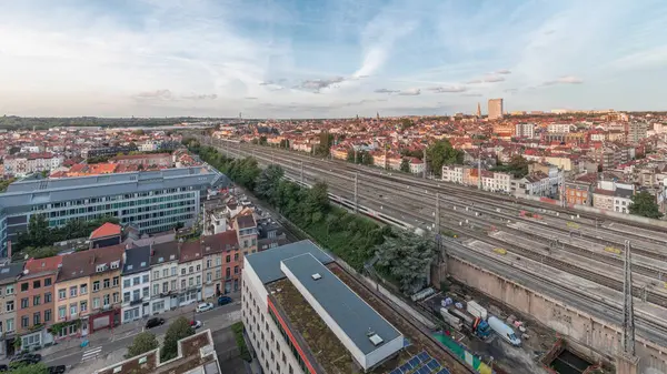 Brüksel Kuzey İstasyonu 'nun tren rayları, gelen ve giden trenlerle dolu. Schaerbeek akşam şehir manzarası kırmızı çatılar, sanayi bölgeleri ve bulutlu bir gökyüzü. Belçika