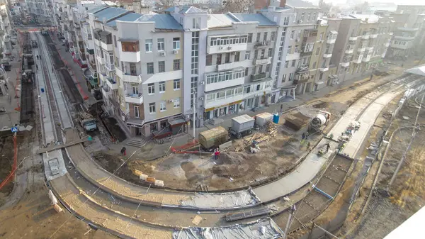 Beton yol yapımında çok sayıda işçi ve mikser makinesi, vinç, traktör zaman ayarlı çalışır. Tramvay raylarının yeniden inşası. Asfalt değirmeninin hava üst görünümü