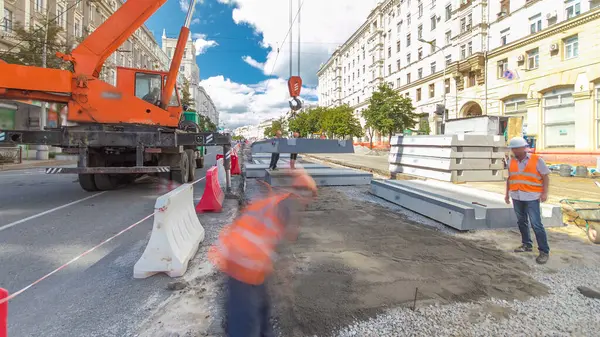 Vinç yol inşaat site timelapse hyperlapse, beton plaka yükleme. Kavganın ve üniforma ile sanayi işçileri. Sokak şehir tramvay yeniden inşası izler