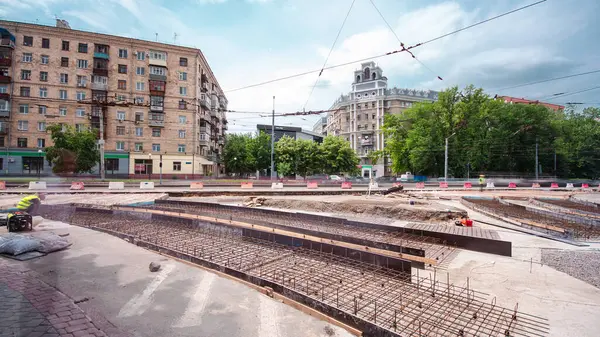 Tramvay rayları onarımı ve bakım zamanı olan bir yol inşaatı. Beton kavşağın orta kısmında işe yarar. Beton taban için metal ızgara