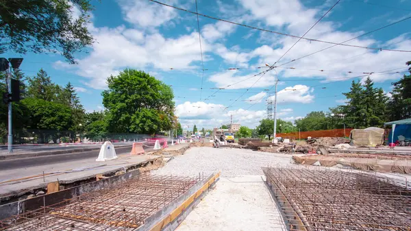 Tramvay rayları onarımı ve bakım zamanı olan bir yol inşaatı. Buldozer kavşağın ortasında ezilmiş taşı dümdüz eder..
