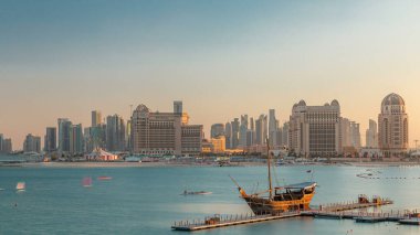 Katara Sahili 'nden Doha, Katar' da gün batımında Batı Körfezi 'ne ve şehir merkezine doğru bir görüntü. Öndeki eski gemi