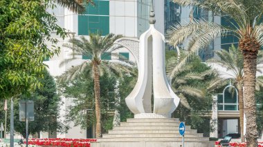 Doha Corniche kahve demliği anıtlı zaman dilimi. Arka planda modern gökdelenler ve yanlarda palmiyeler